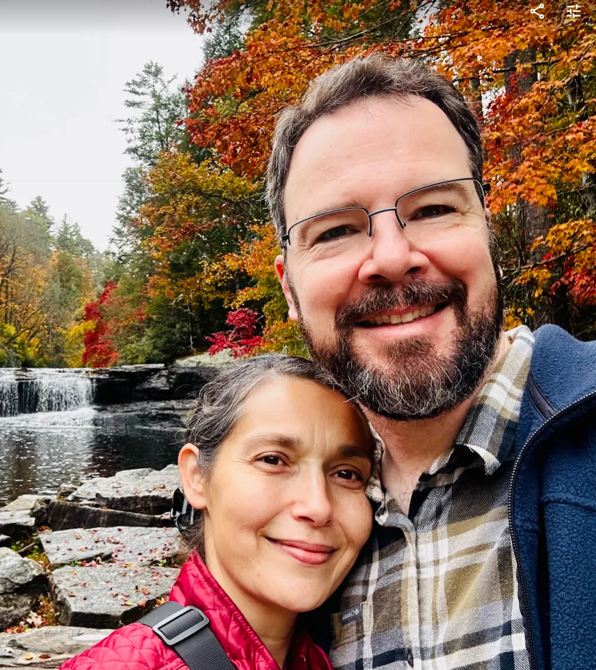 Brother Bob and Monica standing together at a waterfall.
